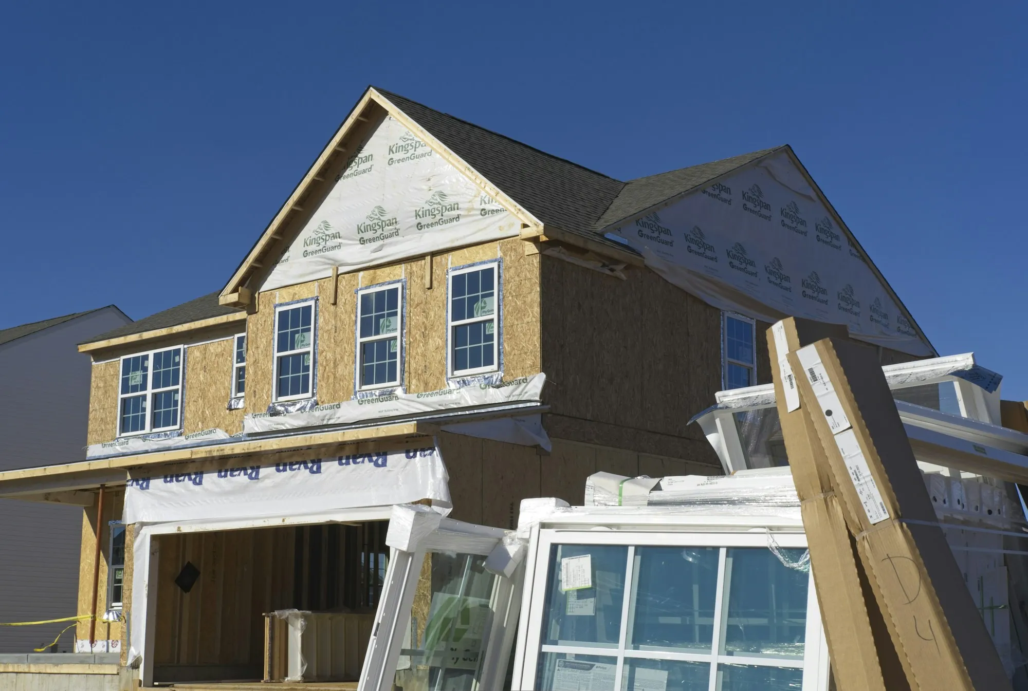New house with sheathing and windows being installed